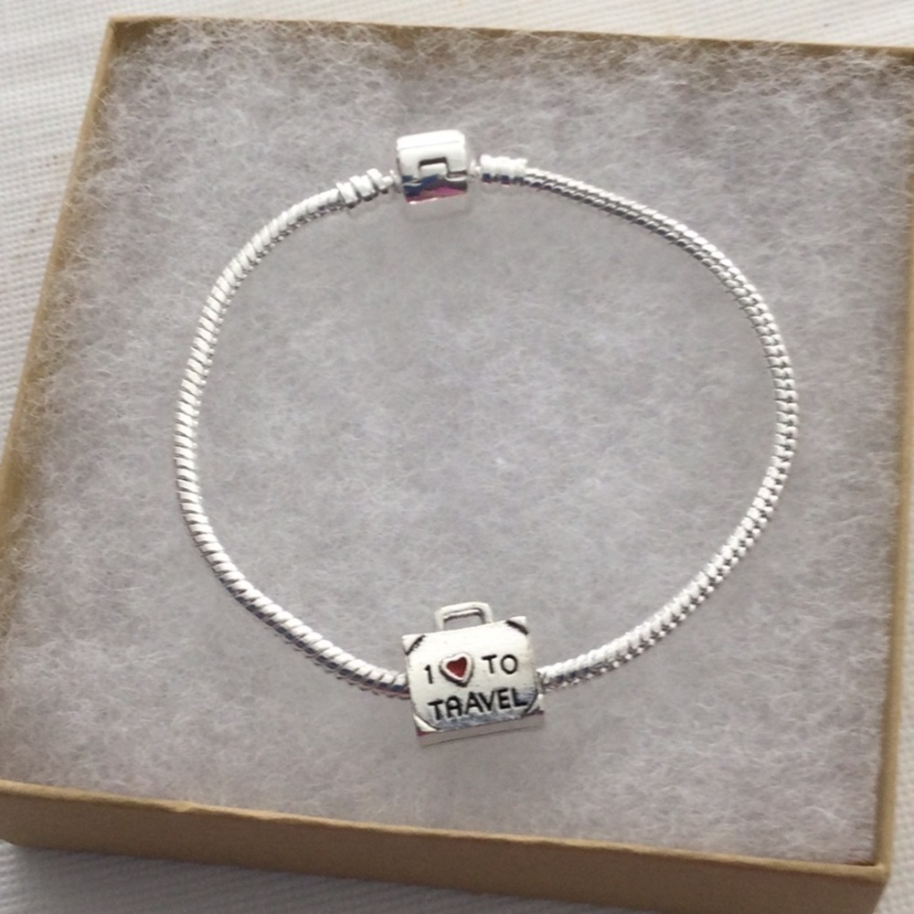 Woman’s Bracelet with one charm that reads I love to travel color sliver.NWOT